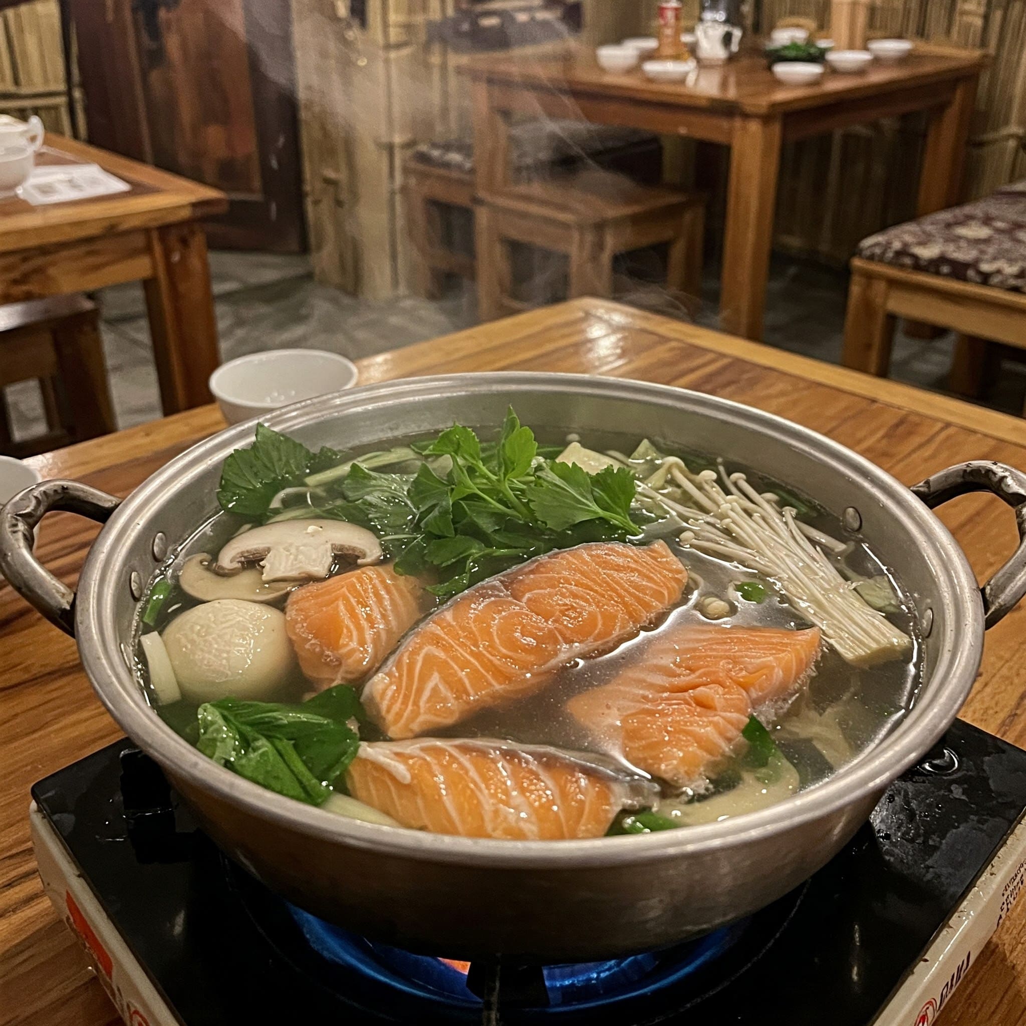 Bubbling salmon hotpot, a Sapa specialty, with fresh herbs and chili